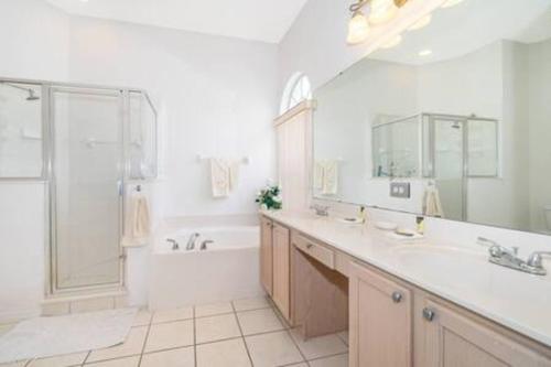 a bathroom with a tub and a sink and a shower at Unique comfortable Golf course Home w Private Pool in Davenport