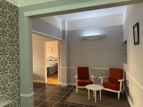 two chairs and a table in a hallway with a bed at Hotel Lyon by MH in Buenos Aires