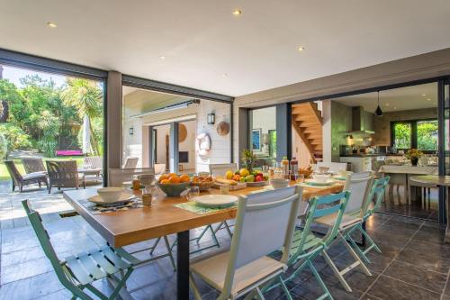 une cuisine et une salle à manger avec une table et des chaises dans l'établissement Villa Sachmatal au coeur du Cap ferret, à Lège-Cap-Ferret