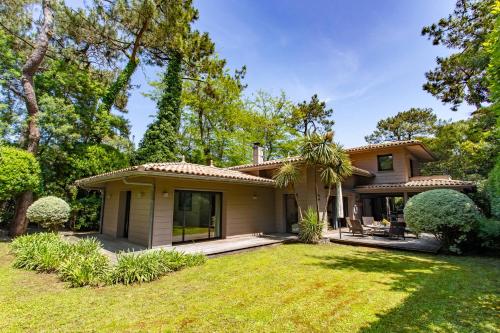 une maison avec un jardin devant dans l'établissement Villa Sachmatal au coeur du Cap ferret, à Lège-Cap-Ferret