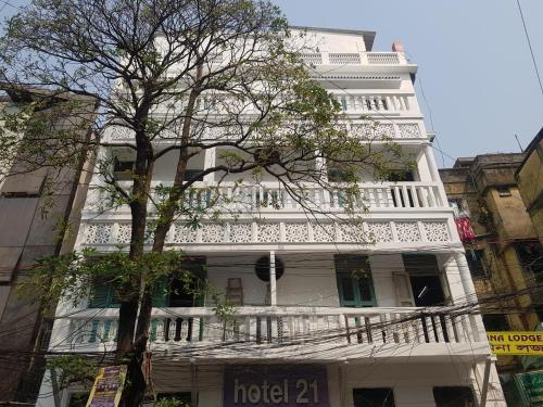 コルカタにあるHotel 21の白い建物の横にバルコニーがあります。
