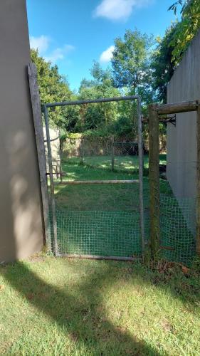 a fence with a gate in the grass at Country Breez Inn - Port Elizabeth in Gqeberha