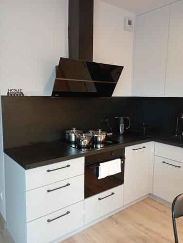 a kitchen with white cabinets and a stove top oven at Apartament noclegi in Sandomierz