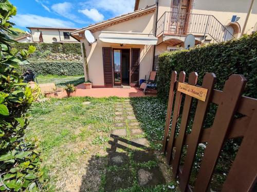 a wooden fence in front of a house at La casa di Arturo Pet friendly Apartments in Riparbella