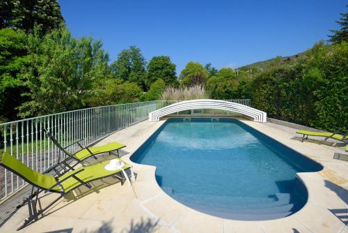 - une piscine avec 2 chaises et un pont dans l'établissement Le Cabanon des Micocouliers, à Manosque