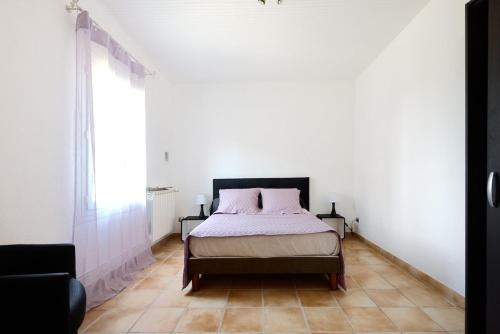 une chambre avec un lit et une grande fenêtre dans l'établissement Le Cabanon des Micocouliers, à Manosque