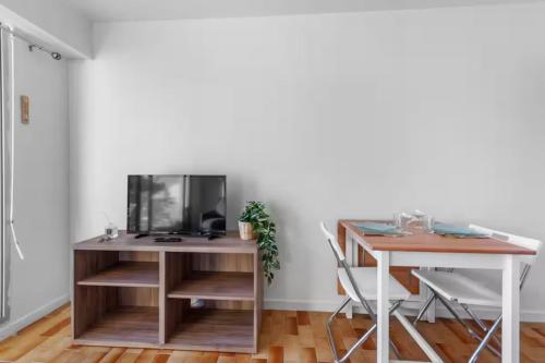 Cette chambre dispose d'un bureau, d'une table et d'une télévision. dans l'établissement Apartment with area view on the golf of Houlgate, à Houlgate