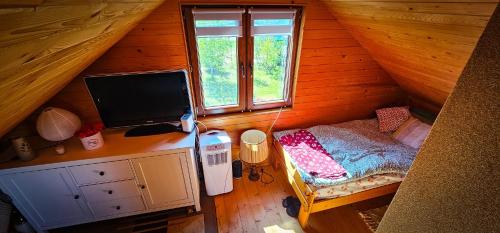 a bedroom with a desk and a computer in a cabin at Bajtkowski Zakątek in Bajtkowo