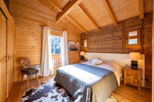 une chambre avec un lit dans une cabane en rondins dans l'établissement Chalet Les Rennes, à Saint-Étienne-de-Tinée