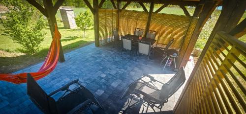 a porch with chairs and a table and a hammock at Bajtkowski Zakątek in Bajtkowo