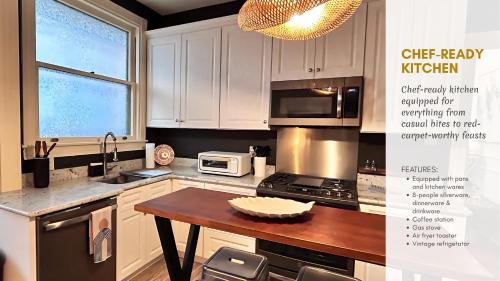 a kitchen with white cabinets and a table and a microwave at Hollywood Glam Themed Manor with Sauna for 12-People in Lancaster