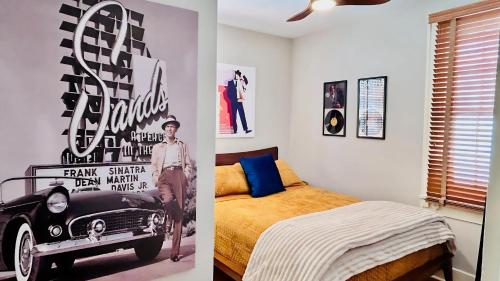 a bedroom with a bed and a poster of a car at Hollywood Glam Themed Manor with Sauna for 12-People in Lancaster
