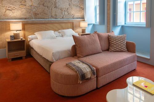 a hotel room with a bed and a couch at Apartamentos The Arc Carrís in Porto
