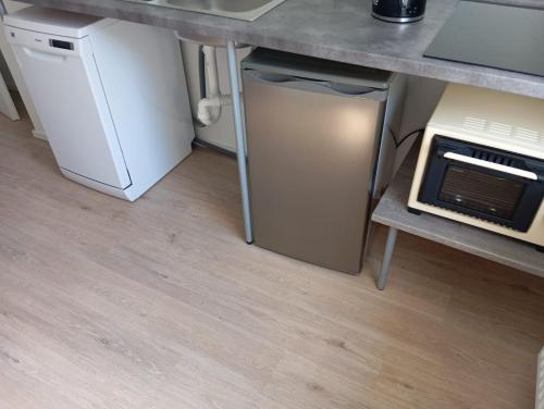 a small refrigerator under a counter in a kitchen at Hauptstr 10- 04603 Remsa in Windischleuba