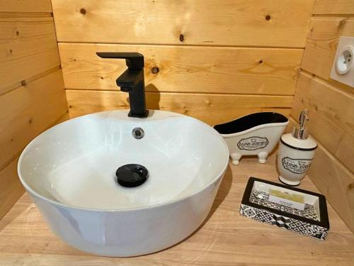 a bathroom with a white sink in a room at Les Philous Gourmands in LʼÉpaux