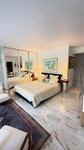 une chambre avec un grand lit avec un grand miroir dans l'établissement Studio basse californie cannes, à Cannes