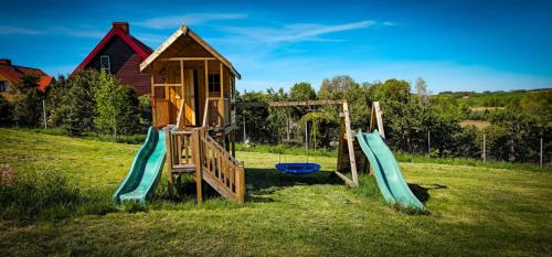 a playground with two slides in a field at Bajtkowski Zakątek in Bajtkowo