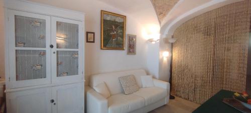 a living room with a white couch and a chair at Dimora Maltese in Morciano di Leuca