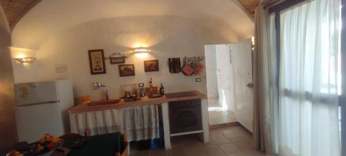 a kitchen with a counter and a refrigerator at Dimora Maltese in Morciano di Leuca
