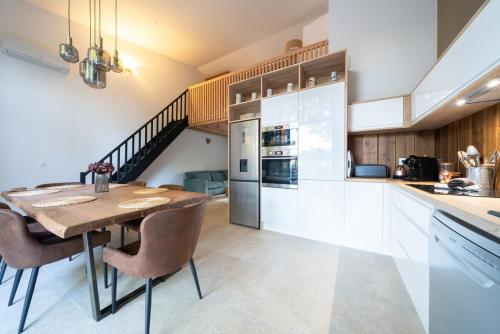 une cuisine avec une table et des chaises ainsi qu'un escalier dans l'établissement Maison du Ponton, bord de canal à Cazaux, à La Teste-de-Buch