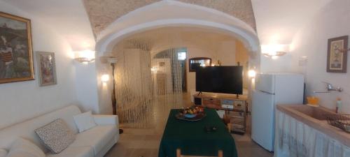 a living room with a white couch and a television at Dimora Maltese in Morciano di Leuca