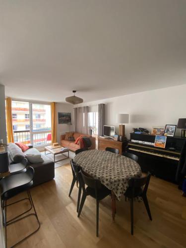 un salon avec une table et un canapé dans l'établissement Spacious and Elegant 3 Bedrooms Apartment near Metro and Bois de Vincennes, à Paris