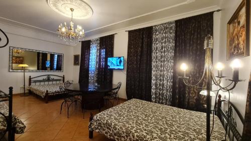 a bedroom with two beds and a table and a chandelier at Villas de Nazare in Maceira