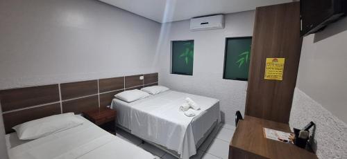 a small room with two beds in it at Hotel Borari in Alter do Chao