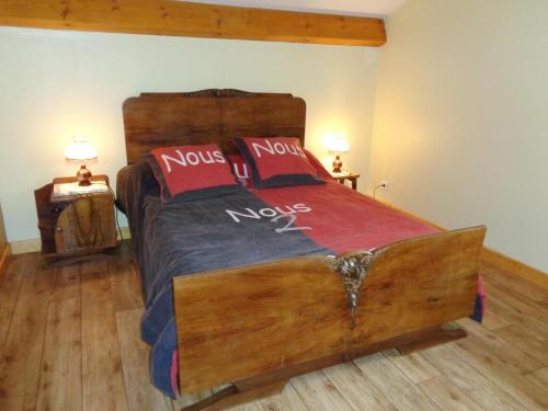 a bedroom with a wooden bed with red pillows at Gite de la croix in Apinac