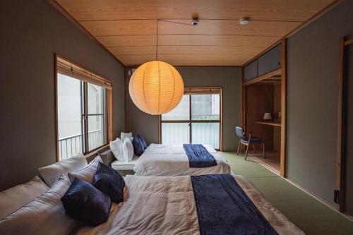 a large bedroom with two beds and a chandelier at 6-minute walk to Tokyo Skytree Up to 6 people 68 sqm fully renovated direct access to Asakusa, Shibuya, Narita Airport, and Haneda Airport in Tokyo