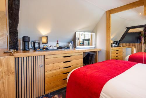 a bedroom with a bed and a sink and a mirror at Quob Park Old House Hotel & Spa in Fareham