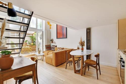 - un salon avec un escalier, une table et des chaises dans l'établissement Bright loft with terrace - Belleville, à Paris