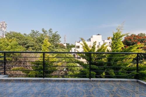 a balcony with a black railing and trees at Whispering Willows By Red Olive 3BHK Near Airport in Yelahanka