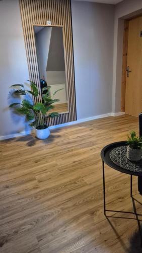 a living room with a table and a mirror at Pension STELLA in Lutherstadt Eisleben