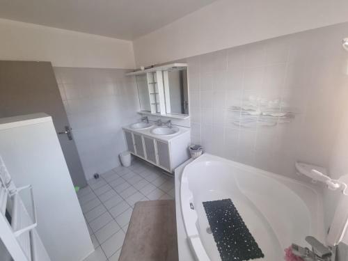 une salle de bain blanche avec une baignoire et un lavabo dans l'établissement Maison avec piscine, proche calanques et mer, à Le Rove