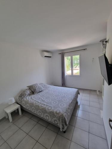 une chambre blanche avec un lit et une fenêtre dans l'établissement Maison avec piscine, proche calanques et mer, à Le Rove