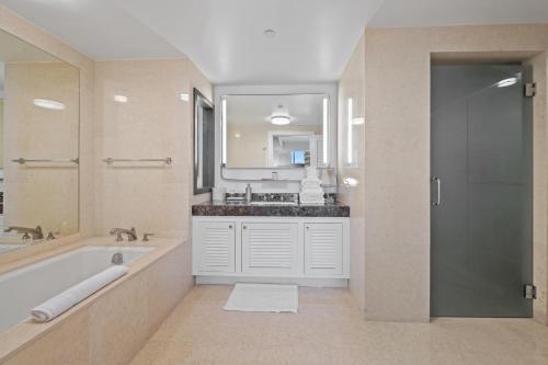 フォート・ローダーデールにあるRitz-Carlton Luxury Oceanview 3-Bedroom Residenceの浴槽、洗面台、鏡のあるバスルーム