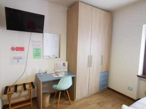 a bedroom with a desk and a cabinet at B & B La Mela in Darfo