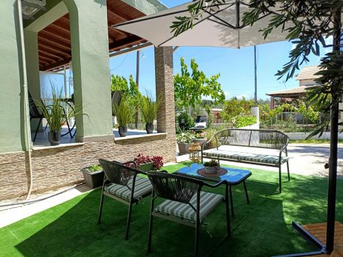 a patio with a table and chairs and an umbrella at Marathi Apartment in Marathias