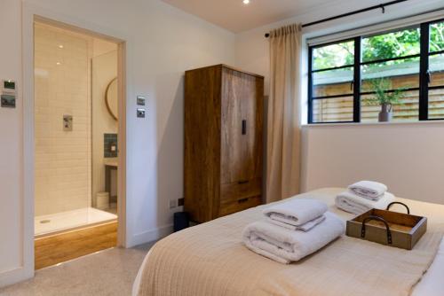 a bedroom with a bed and a bathroom with a shower at Verdant Rise - Contemporary Country Retreat in Albourne