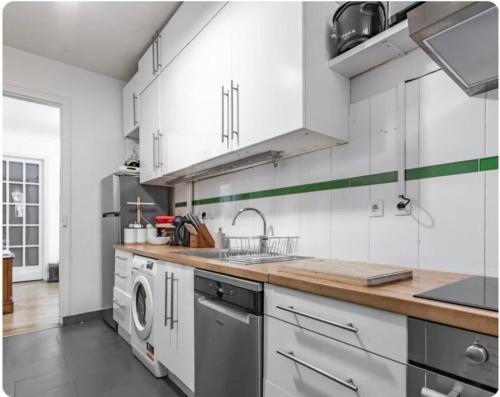 une cuisine avec un évier et une machine à laver dans l'établissement Maison à Paris, à La Celle-sous-Gouzon