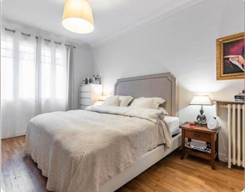 une chambre blanche avec un grand lit et une table dans l'établissement Maison à Paris, à La Celle-sous-Gouzon