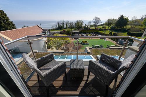 a balcony with two chairs and a swimming pool at Holm House - Stylish Coastal Suites - Silures Bar & Restaurant On-site in Cardiff