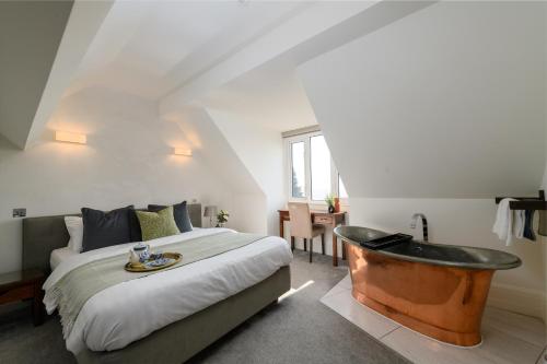 a bedroom with a bed and a bath tub at Holm House - Stylish Coastal Suites - Silures Bar & Restaurant On-site in Cardiff