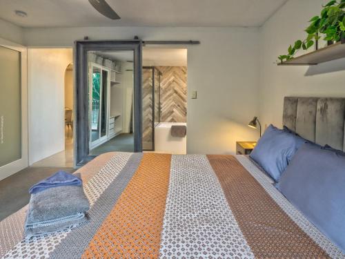a bedroom with a large bed and a bathroom at Stunner 2 min walk to beach in Torquay