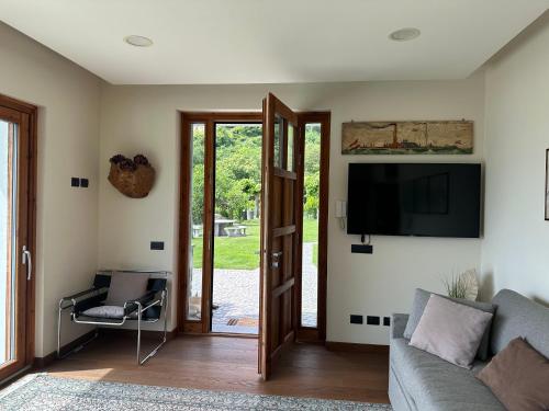 a living room with a couch and a tv at Bellagio Lake View apartment Rosabella with swimming-pool in Civenna