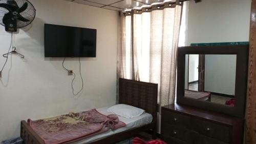 a small bedroom with a bed and a mirror at white onion hotel and restaurant in Murree
