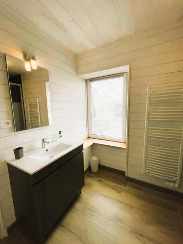 une salle de bain avec un lavabo et une fenêtre dans l'établissement L'Amiral - vue mer sur le port, à Roscoff