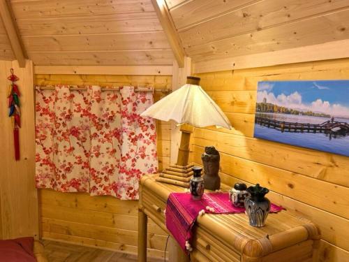 une pièce avec une lampe sur une table dans une cabine dans l'établissement Les Philous Gourmands, à LʼÉpaux