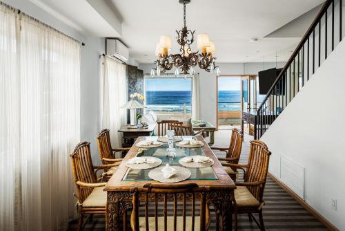 Un comedor con mesa y sillas y el océano. en New The Triton Manhattan Beachfront Escape, en Manhattan Beach